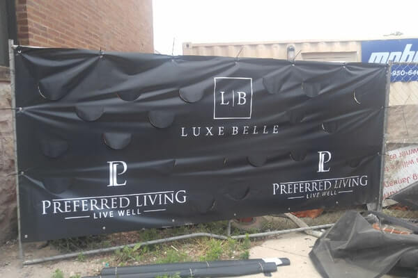 black fence banner with slits cut for airflow